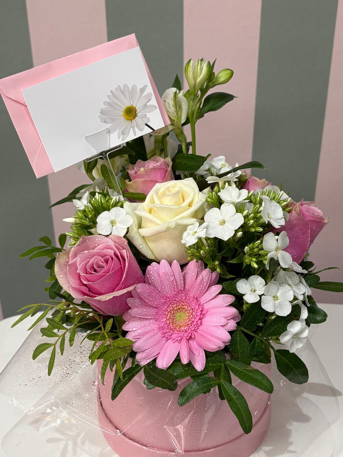 Pink and cream roses with pink gerbera and white flowers in a pink hat box at The Flower Cottage